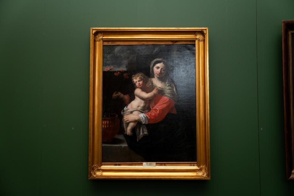 Painting in a gilded frame depicting a woman holding a nude child against a dark background.