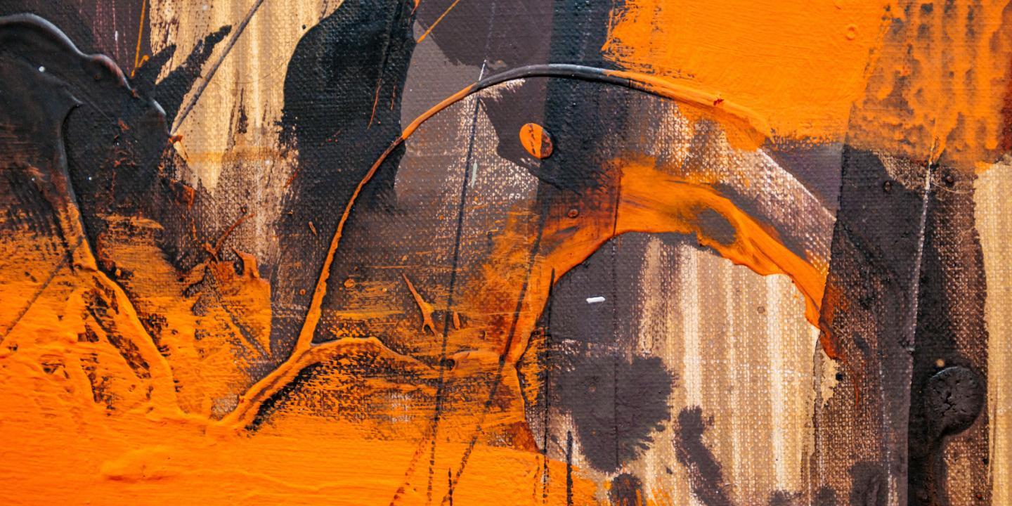 Abstrakta gleznojuma fragments ar koši oranžiem un tumšiem triepieniem, kas veido dinamisku, teksturētu virsmu.