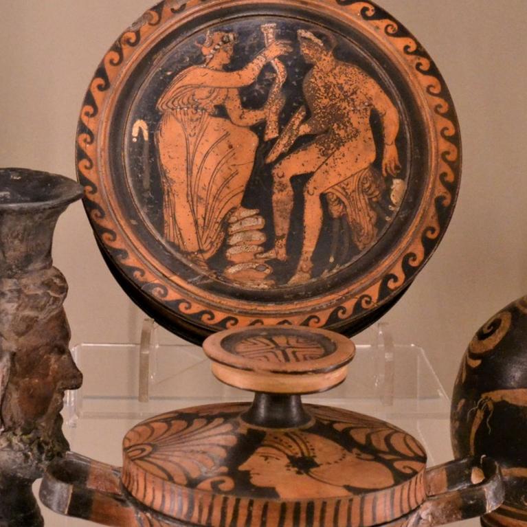 Senās Grieķijas keramika ar melno figūru un sarkano figūru gleznojumiem, attēlojot mitoloģiskas ainas uz vāzēm un traukiem.