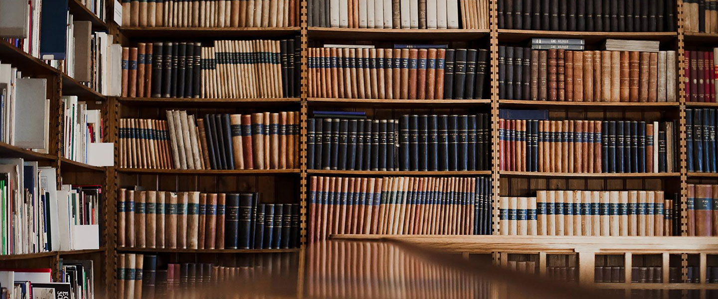 Plaukti piepildīti ar grāmatām bibliotēkas telpā ar koka interjeru.
