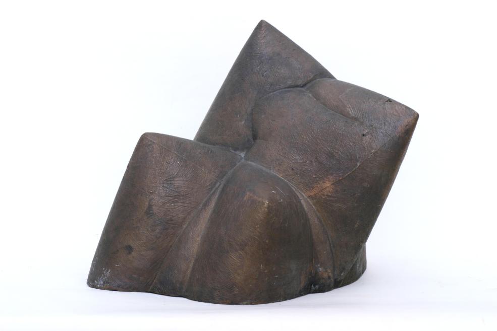 Abstract dark wooden sculpture with sharp geometric planes on a white background.
