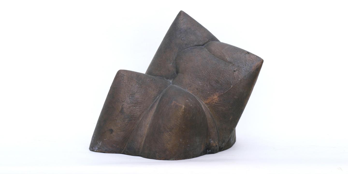 Dark bronze abstract sculpture with geometric folded planes on a white background.