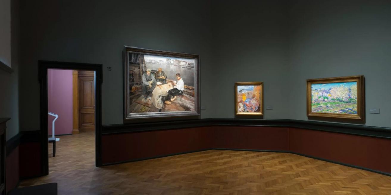 Exhibition at the Latvian National Museum of Art showcasing realist and impressionist-style paintings.