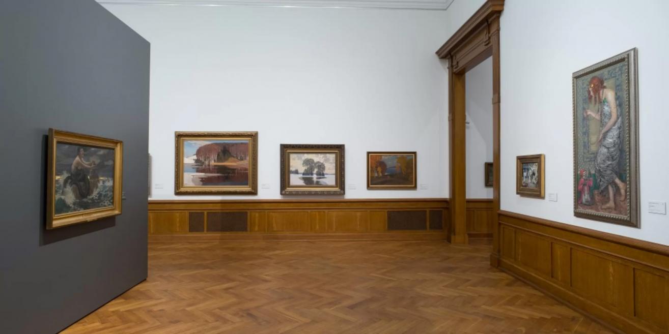 Permanent exhibition hall of the Latvian National Museum of Art with early 20th-century landscapes and figurative compositions.