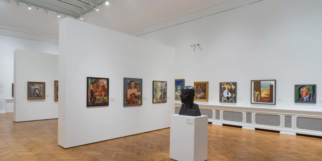 Exhibition hall of the Latvian National Museum of Art featuring 20th-century portraits and modernist paintings.