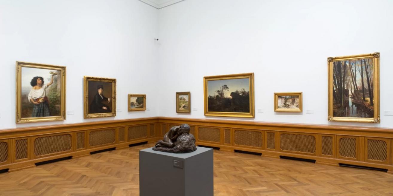 Exhibition at the Latvian National Museum of Art displaying portraits and landscapes from the late 19th and early 20th centuries.