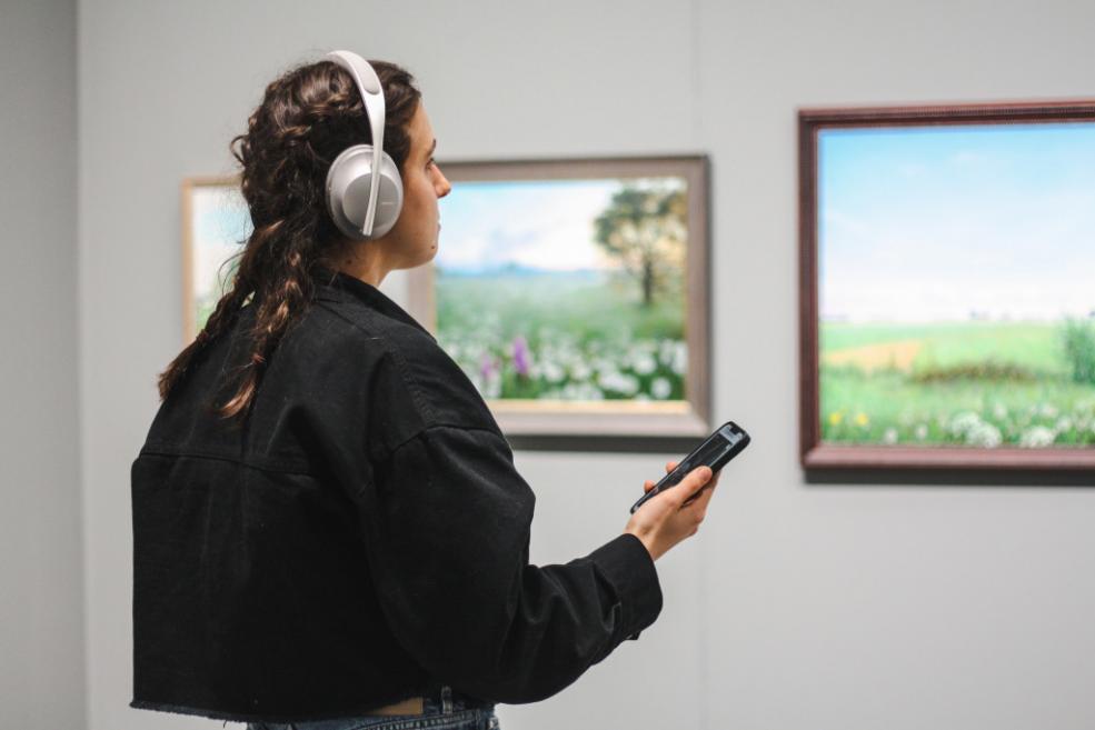 Apmeklētājs ar audiogidu izstādē &ldquo;Imanta Lancmaņa māksla&rdquo; Latvijas Nacionālajā mākslas muzejā. Rīga, 2022./2023. Foto: Kortnija Māra Gurtlava