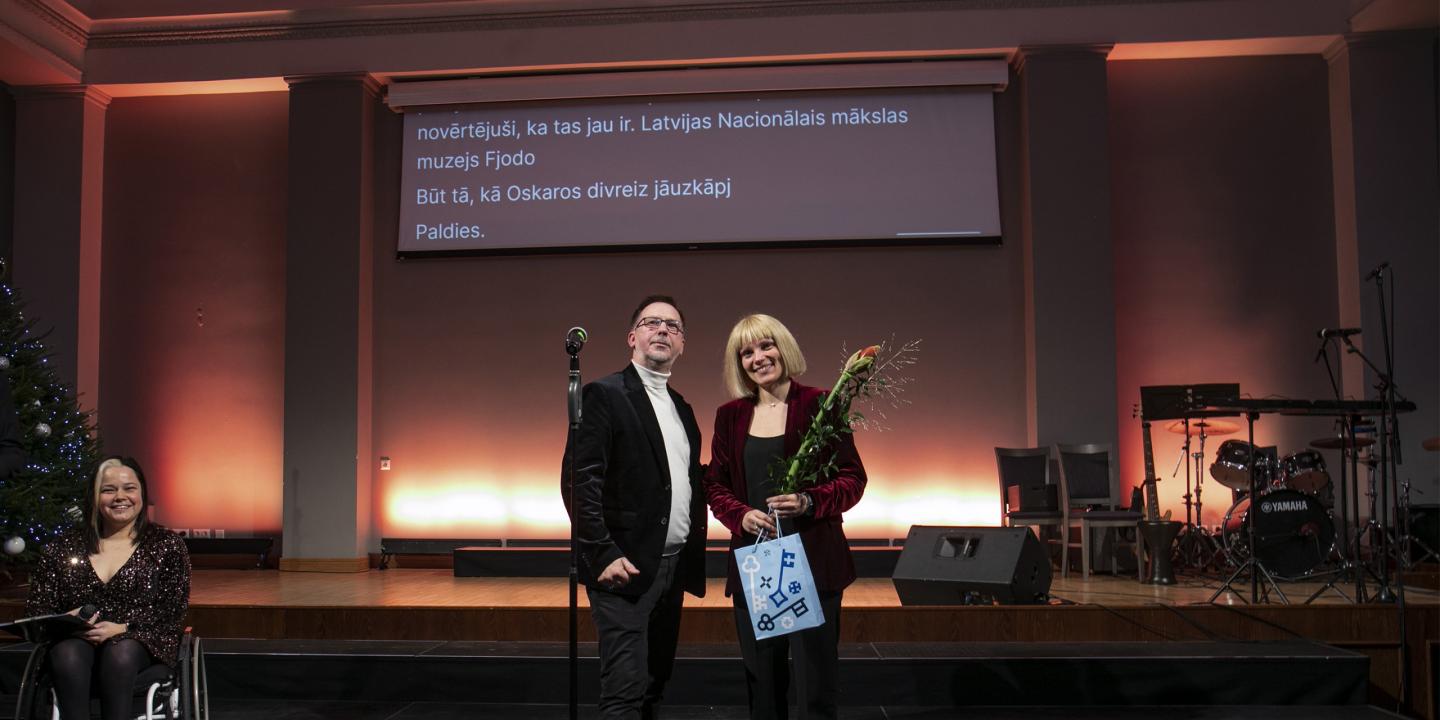 Latvijas Nacionālā mākslas muzeja pārstāve uz skatuves saņem atzinību par ieguldījumu kultūras piekļūstamības veicināšanā Rīgā.