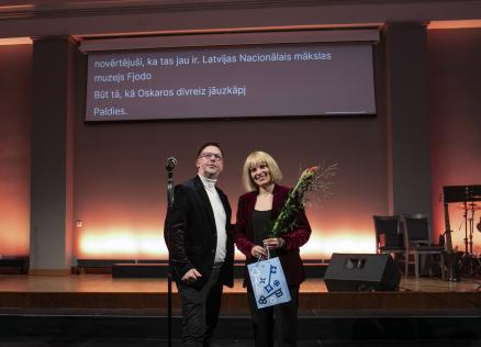 Latvijas Nacionālā mākslas muzeja pārstāve uz skatuves saņem atzinību par ieguldījumu kultūras piekļūstamības veicināšanā Rīgā.