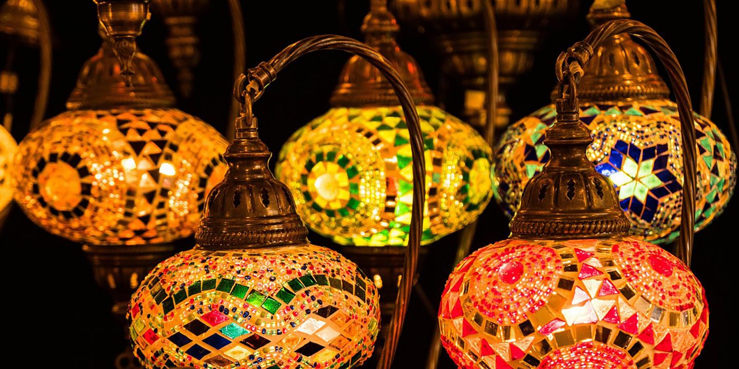 Colorful glass mosaic lamps with bronze metal details illuminate the space in warm tones.