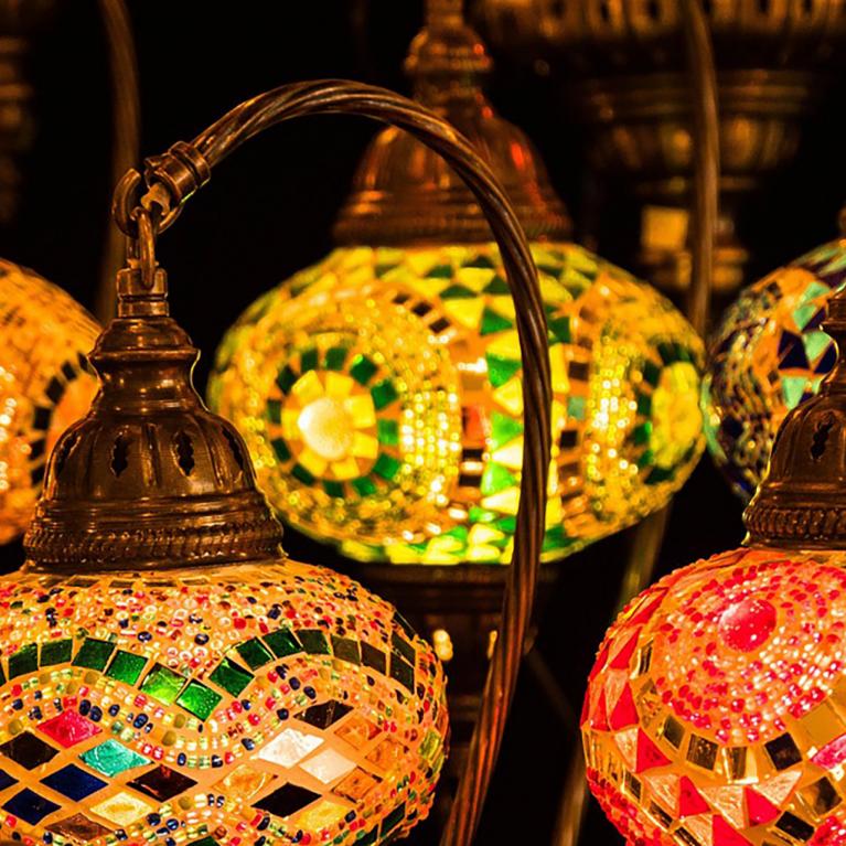Colorful glass mosaic lamps with bronze metal details illuminate the space in warm tones.