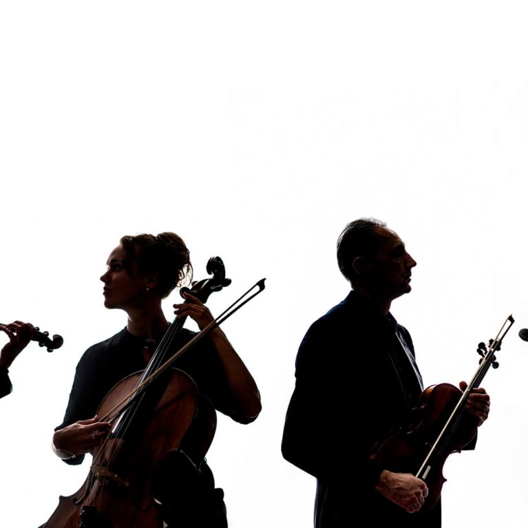 Four musicians in silhouette play string quartet instruments – two violins, a viola, and a cello.