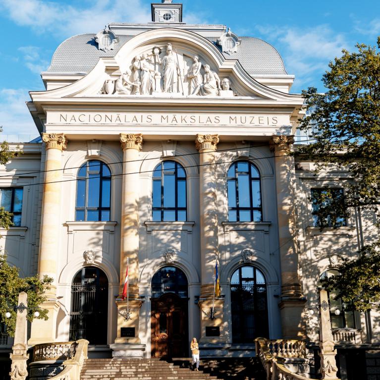 Latvijas Nacionālā mākslas muzeja galvenā ēka Rīgā, skatīta no priekšpuses saulainā dienā.