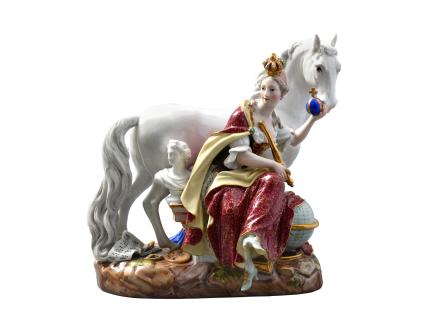 Porcelāna figūriņa ar sēdošu kronētu sievieti un baltu zirgu uz dekoratīvas pamatnes.