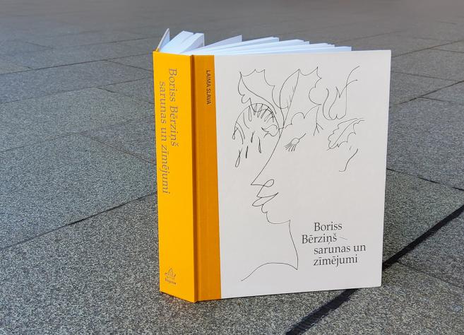 Grāmata "Boriss Bērziņš – sarunas un zīmējumi" novietota uz bruģa.