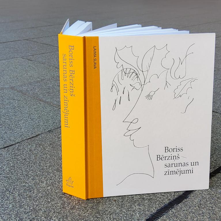 Grāmata "Boriss Bērziņš – sarunas un zīmējumi" novietota uz bruģa.