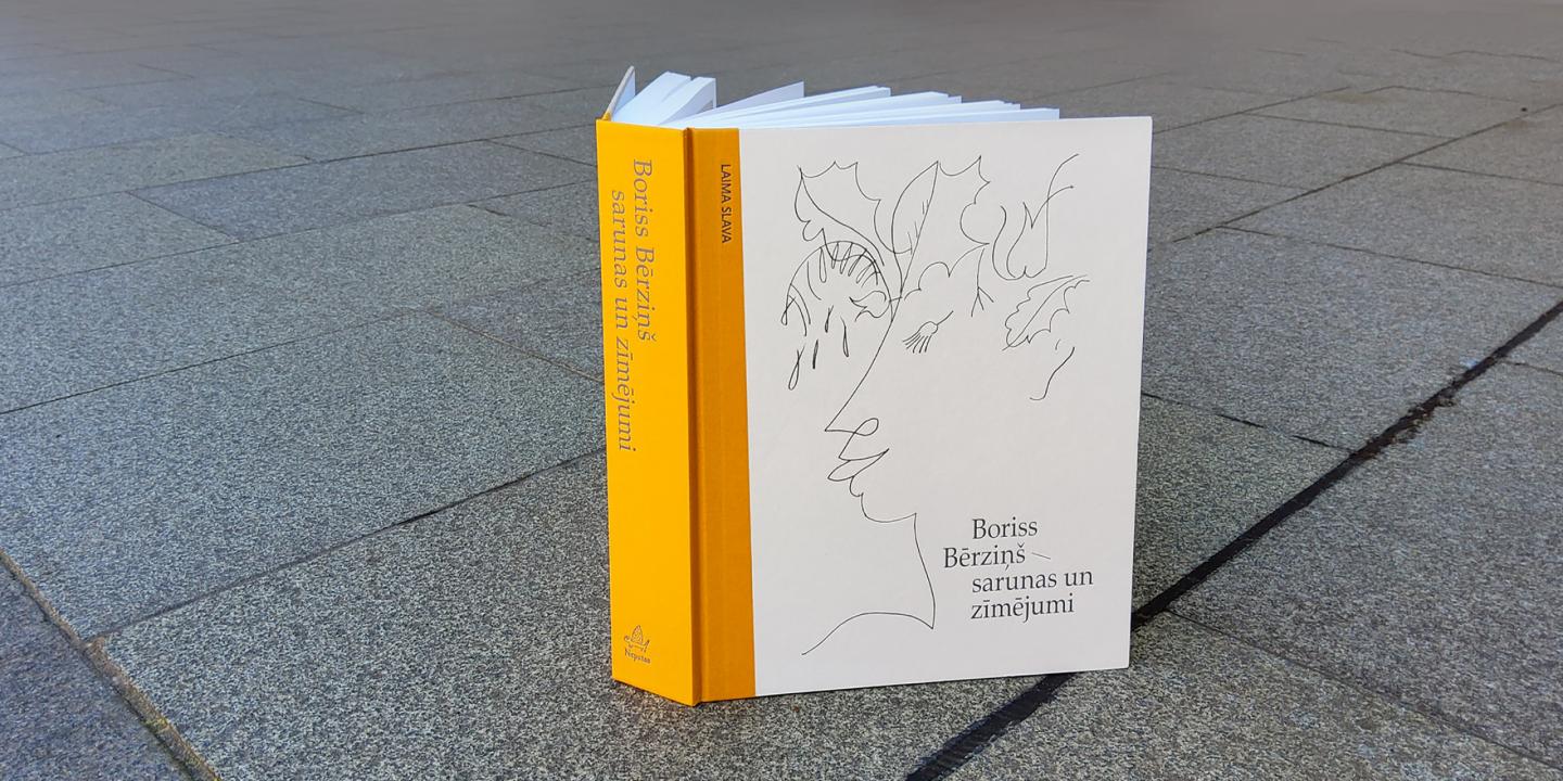 Grāmata "Boriss Bērziņš – sarunas un zīmējumi" novietota uz bruģa.