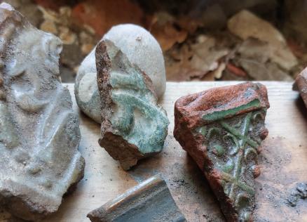 Arheoloģiski atrasti 17. gadsimta krāsns podiņu fragmenti: glazētas keramikas lauskas ar reljefiem ornamentiem un zaļganas glazūras pēdām, nolietotas un klātas ar zemes nogulsnēm.