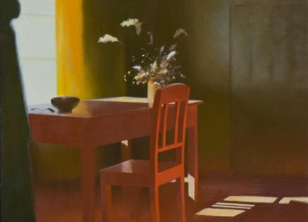 A still life with a red table and chair; on the table, a ceramic bowl and a vase with wildflowers. Light pours in from a window on the left, casting shadows on the floor and walls.
