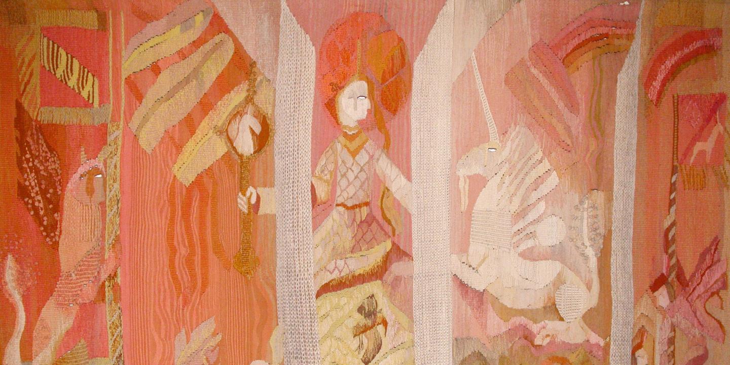 Tapestry in warm pink and orange tones depicting a stylized figure, a unicorn, and decorative ornaments.