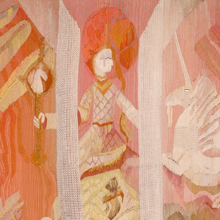 Gobelēns siltos rozā un oranžos toņos ar stilizētu figūru, vienradzi un dekoratīviem ornamentiem.