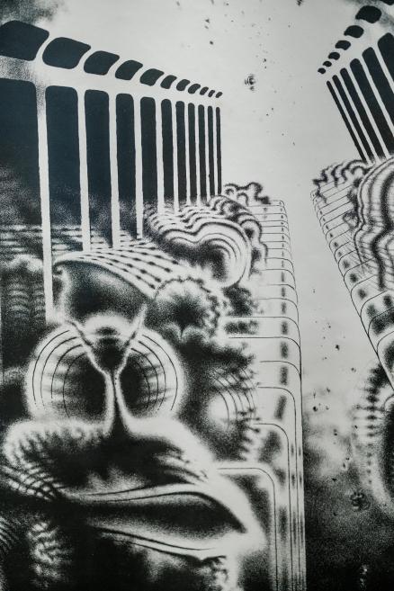 A black-and-white surreal composition featuring stylized faces and a repeating rhythm of architectural columns in perspective.