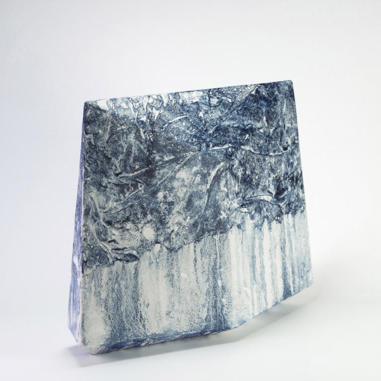 Abstrakta melnbalta kompozīcija ar koncentriskām, viļņveida līnijām un tumšu, savītu formu centrā.