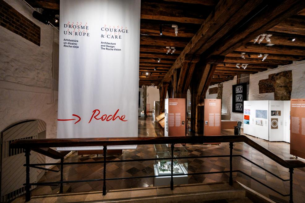 Izstādes ieejā redzams liels vertikāls baneris “Courage &amp; Care. Architecture and Design: The Roche Vision”.