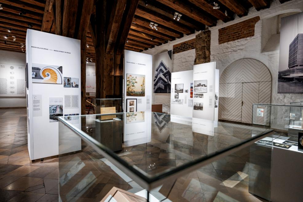 Izstādes zāle ar stikla vitrīnām un stendiem, kuros apskatāmi Roche arhitektūras un dizaina materiāli.