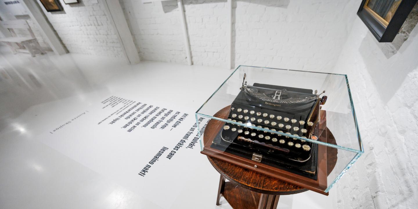 Muzeja ekspozīcijā uz neliela galdiņa zem stikla pārsega novietota vēsturiska rakstāmmašīna, bet uz grīdas redzams tipogrāfisks teksta fragments.