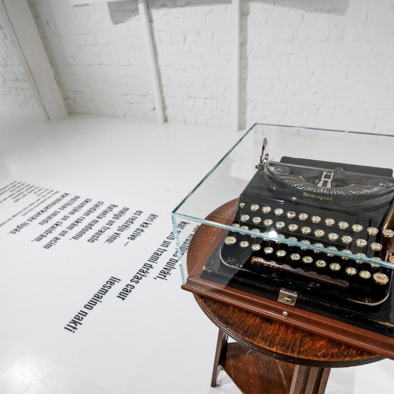 Muzeja ekspozīcijā uz neliela galdiņa zem stikla pārsega novietota vēsturiska rakstāmmašīna, bet uz grīdas redzams tipogrāfisks teksta fragments.