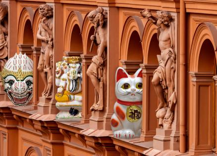 Decorative figures from different cultures are placed between classical sculptures on the museum building façade.