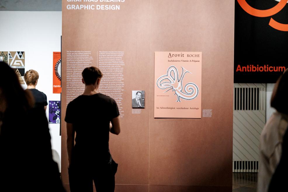 Visitors examine architectural drawings arranged on slanted tables at the exhibition.