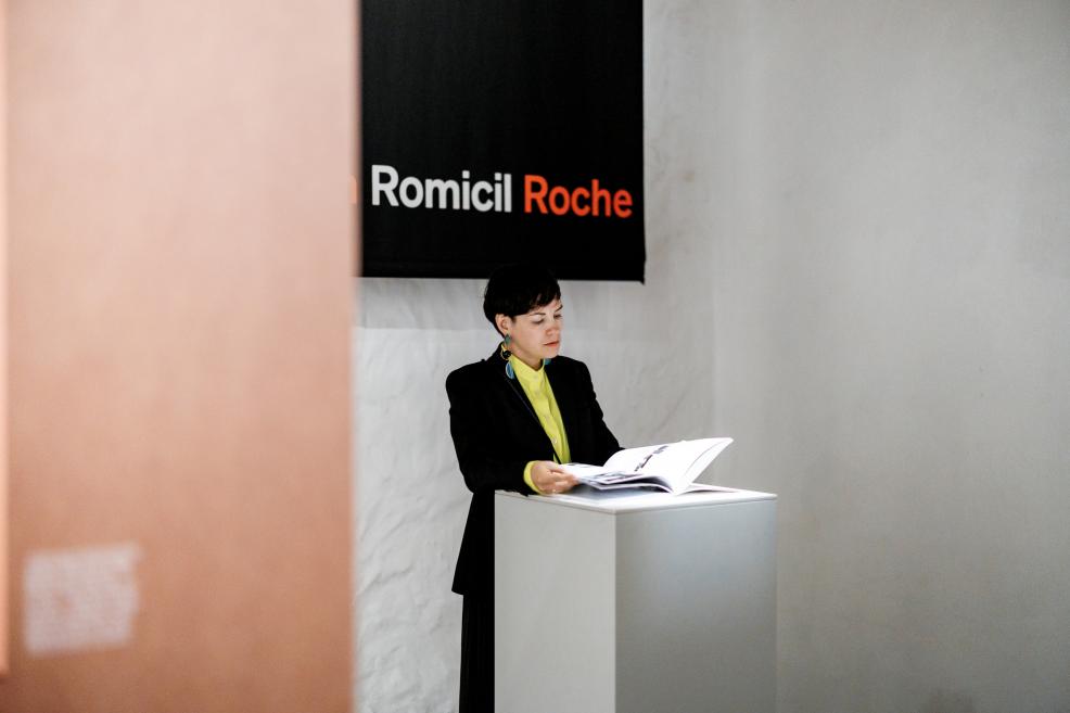 Visitors read information at a panel about Roche graphic design.