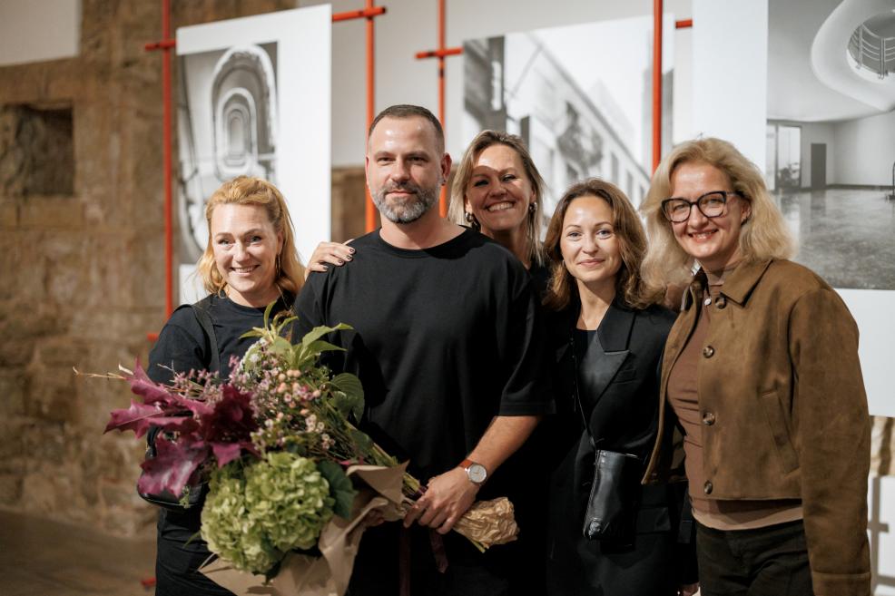 Group of people posing with flowers at the exhibition.