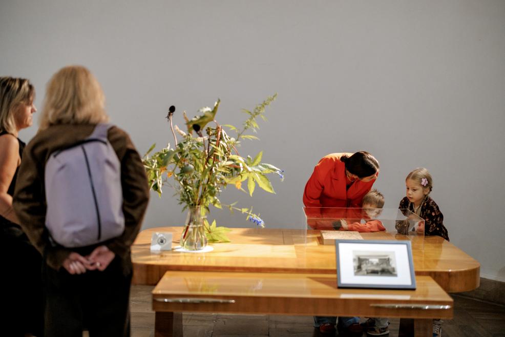 Woman with children looking at a display case with exhibition items.