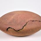 Trīs cilvēki aplūko priekšmetus baltā vitrīnā