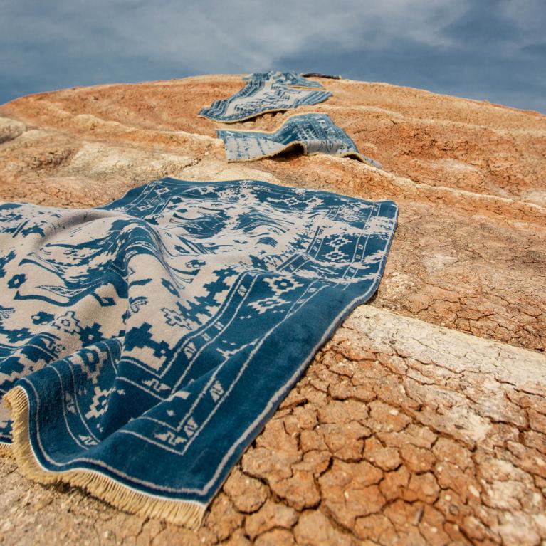 Blue carpets in desert sand.