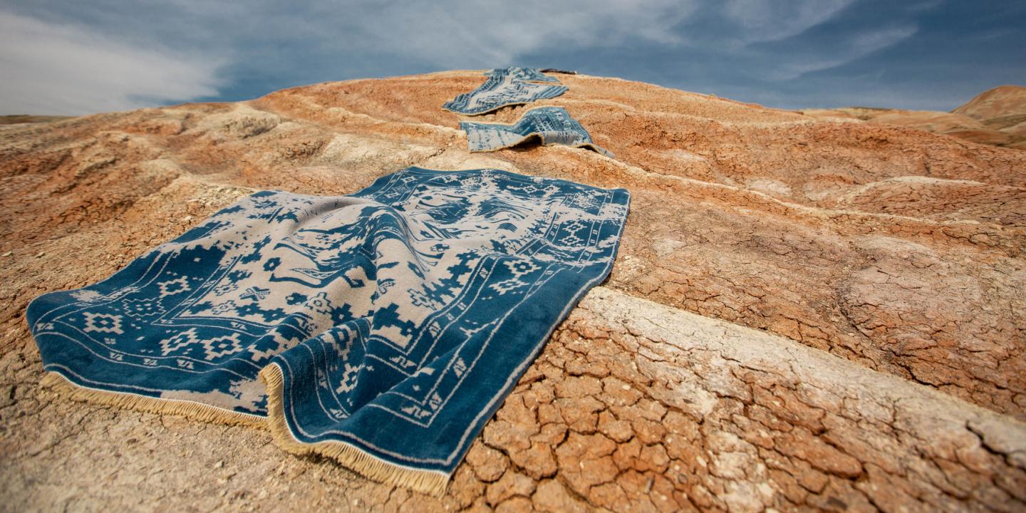 Blue carpets in desert sand.