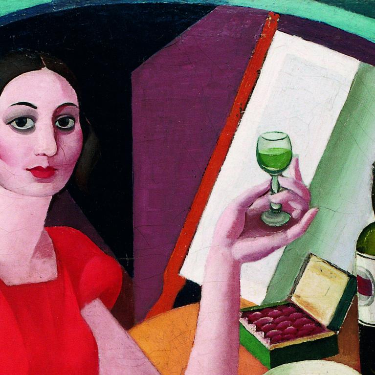 Glezna ar sievieti sarkanā kleitā, kura sēž pie galda un tur rokā glāzi ar zaļganu dzērienu, blakus novietota pudele un atvērta konfekšu kārba.