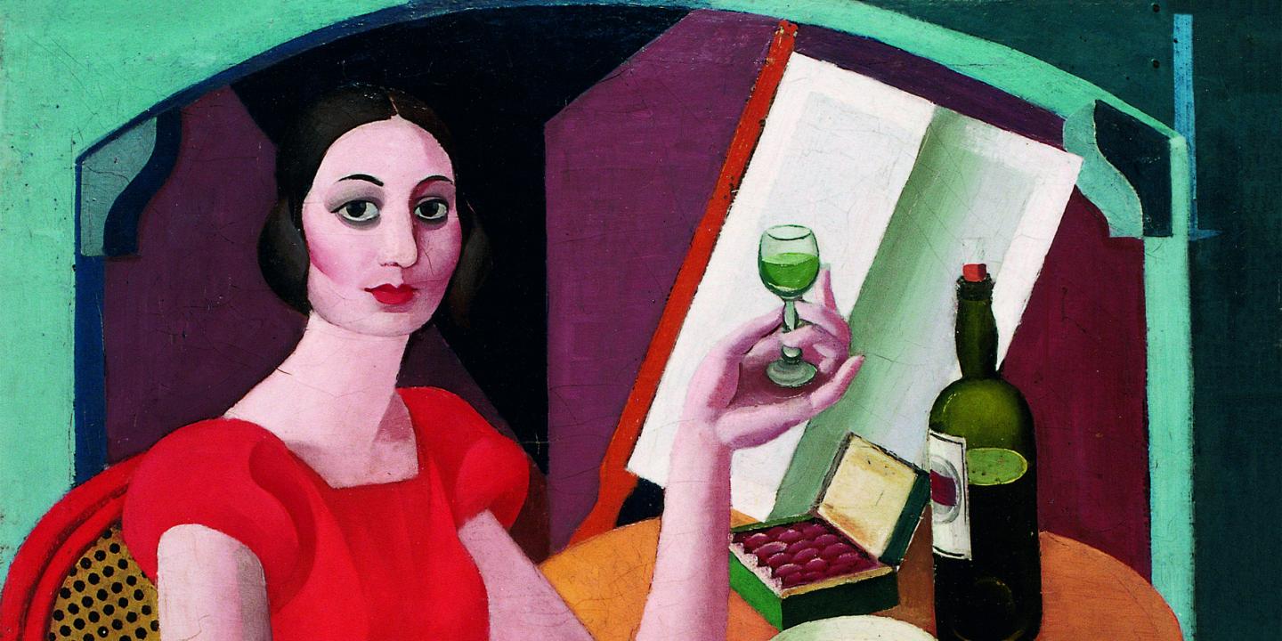 Glezna ar sievieti sarkanā kleitā, kura sēž pie galda un tur rokā glāzi ar zaļganu dzērienu, blakus novietota pudele un atvērta konfekšu kārba.