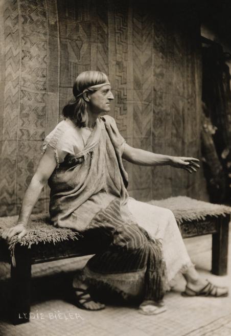 A black and white photograph of a man in performance attire.