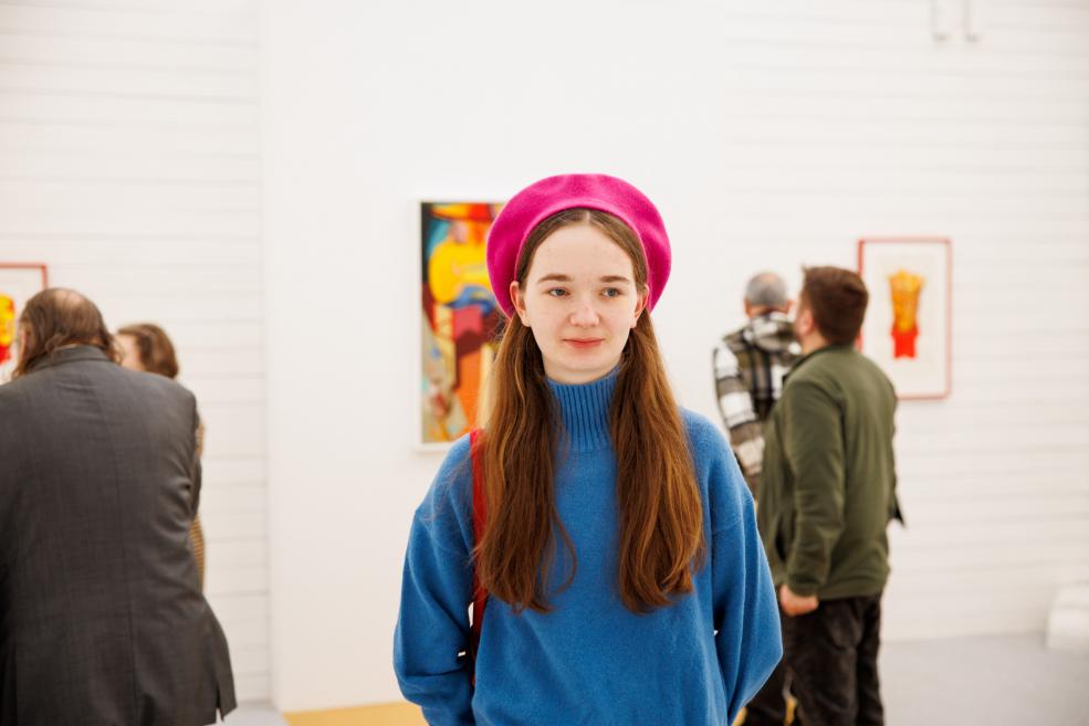 Exhibition visitor with a pink hat.